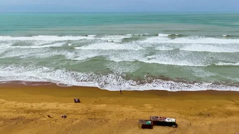 Static drone shot of the ocean with calm waves reaching the shore of a white Stock Footage 284444255