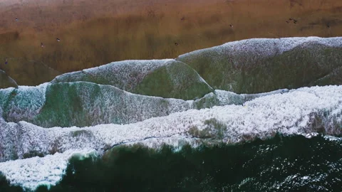 Static drone shot of ocean waves crashing onto a California beach in 4k footage. Video stock 235890219