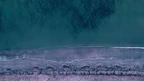 Static drone shot of sea waves washing onto a beach Stock-Footage 345827806