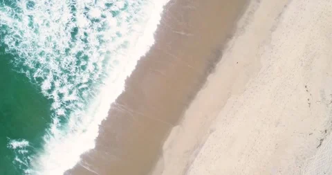 Static drone top down view aerial footage flying over a beach parallel to t.. Video stock 309987508
