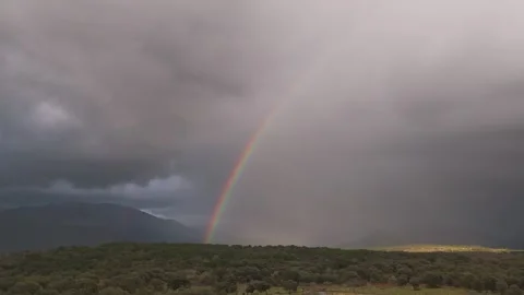 Static drone view of emerging rainbow over mountains after storm at 70mm Vídeos de archivo 339064625