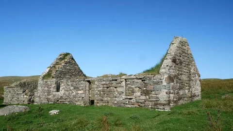 A static establishing long shot of an abandoned, derelict croft / farm house Stock Footage 140511872