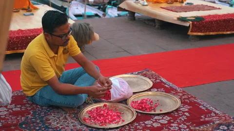 Static high angle shot of man preparing flower petals for ritual offering in Vidéo 348107795