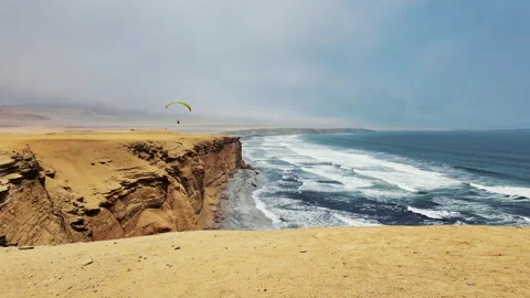 Static image of a paraglider flying over a beautiful beach on the coast of Stock Footage 301847399