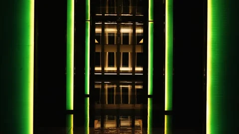 Static interior shot of a dark modern hallway illuminated by vertical green and Stock Footage 343428157