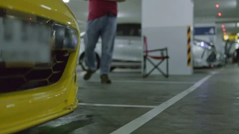 Static low-angle shot focusing on the front bumper and grille of a yellow mod Stock Footage 345654423