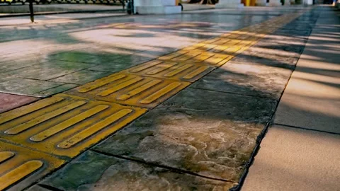 Static low angle shot of tactile paving tiles and yellow guide blocks on a .. 스톡 동영상 342036640