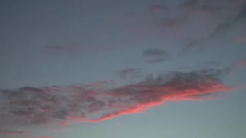 Static low angle view of glowing pink clouds in a dusk sky Stock Footage 337673105