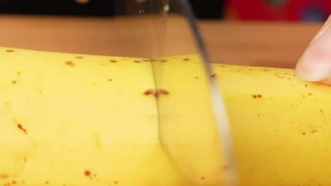 Static Macro Close Up Knife Cutting Ripe Yellow Banana Skin Texture 4K Stock Footage 322142372