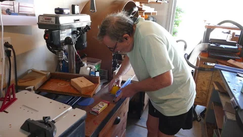 Static Medium Shot of Mature Male Carpenter Using Power Drill Press Machinery Stock Footage 336597908