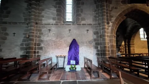 Static medium shot of an open wooden door leading into a historic stone church w Stockbeeldmateriaal 332804042
