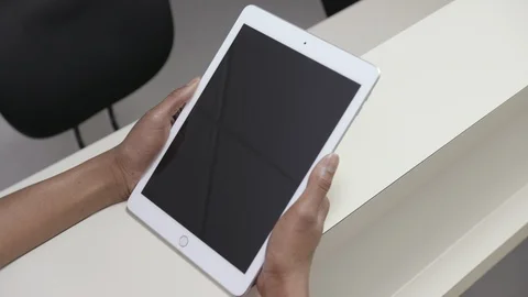 Static, over the shoulder shot of  iPad or tablet held by a female nurse Stock Footage 109503760