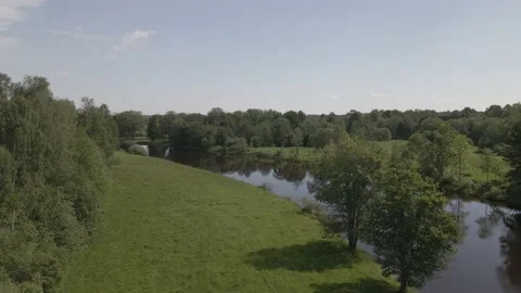Static scene of a calm river flowing through meadows and forests in summer day Stock Footage 159982203
