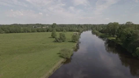 Static scene of a calm river flowing through meadows and forests in summer day Stock Footage 159982217