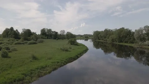 Static scene of a calm river flowing through meadows and forests in summer day Stock Footage 159982634