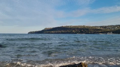 Static sea view with gentle waves and distant coastal hill Stock Footage 320455321