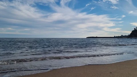 Static seaside view with gentle waves and cloudy blue sky Stock Footage 320455408