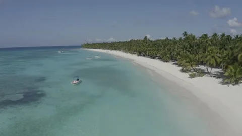 A static shoot over blue water and white beach. Boat on the water. Coastal blue. Stock Footage 140864034
