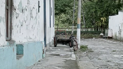 Static shot of abondoned rusty bicycle trailer in rural village, south america Stock Footage 153801727