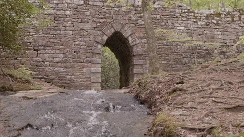Static shot of ancient bridge with stream running under it. Stock Footage 152542921