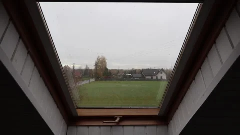 Static shot from an attic room, looking through a wooden skylight window Stock Footage 320945126