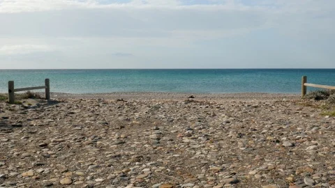 Static shot of a beach with small rocks and sand. Quiet sea. Peaceful. Stock Footage 121575466