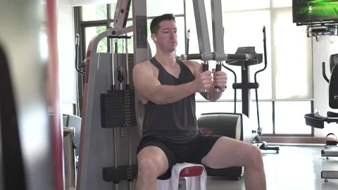 Static shot of a bodybuilder doing chest flys on a cable machine in the gym Stock Footage 301584164