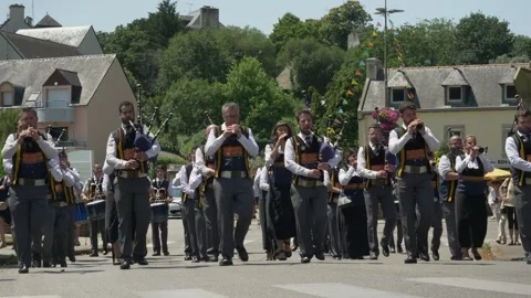 Static shot of Breton bagpipe band marching in bright daylight during cherry Stock Footage 342022801