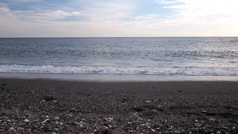 Static shot of a brown sandy beach with the quiet sea and nice dramatic sky. Stock Footage 119106859