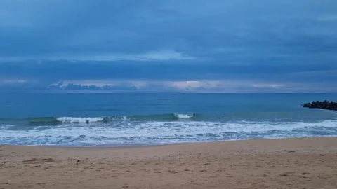 Static shot of calm sea waves under moody blue sky Stock Footage 320253640