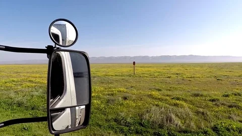 Static shot, of a camper van mirror, while driving between wildflower, Stock Footage 105692639