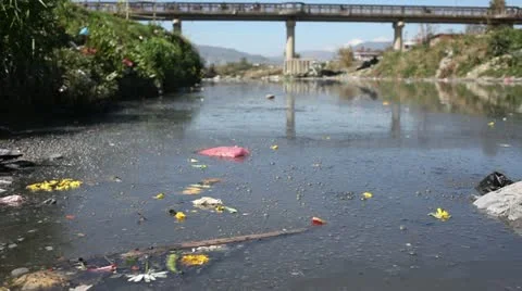 Static Shot: Close up of a polluted river with bridge in the background. 스톡 동영상 22225316