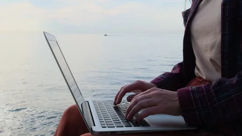 Static shot close-up woman's hands typing on a laptop keyboard outdoors. Stock Footage 253363707