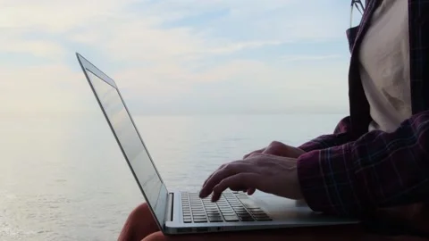 Static shot close-up woman's hands typing on a laptop keyboard outdoors. Видео 253449283