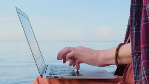 Static shot close-up woman's hands typing on a laptop keyboard outdoors. Stock Footage 254543875