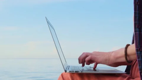 Static shot close-up woman's hands typing on a laptop keyboard outdoors. Stockbeeldmateriaal 255206838