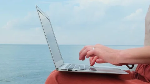 Static shot close-up woman's hands typing on a laptop keyboard outdoors. Stock Footage 258568836