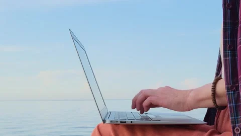 Static shot close-up woman's hands typing on a laptop keyboard outdoors. Видео 262019741