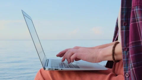 Static shot close-up woman's hands typing on a laptop keyboard outdoors. Видео 263813941