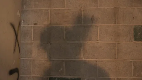 Static Shot Construction Worker Shadow Picking Up Beam on Cinder Block Wall Vidéo 336265797