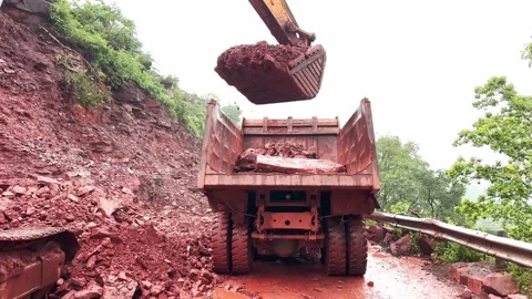 Static Shot of Excavator Loading Landslide Debris Into Dumper Truck on Mountain Stock Footage 344583941