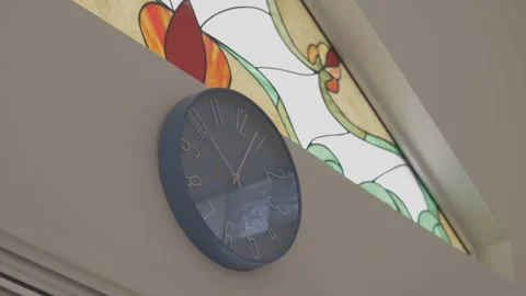 Static shot focused on a clock with a beautiful stained glass window, canon eos Stock Footage 311513603