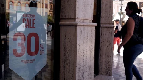 Static shot in front of a clothes shop showing a 30% sale discount sign Stock Footage 118251737