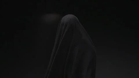 Static shot of Ghost in black robe standing In dark room Stock Footage 208767169
