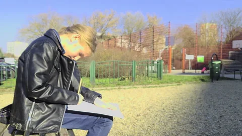 Static shot of girl doing homework at Budapest playground Stock Footage 331765274