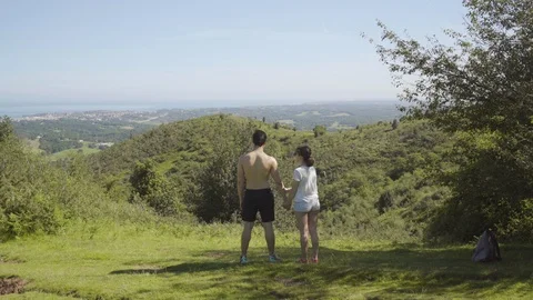 Static shot of a handsome young couple holding hands on top of a mountain with a Stock Footage 111928510