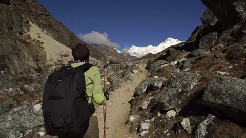 Static shot of a hiker walking through the mountains Stock Footage 104342599