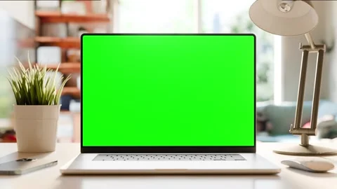 A static shot of a laptop with a green screen on a desk in a home office. T.. Stock Footage 278730073
