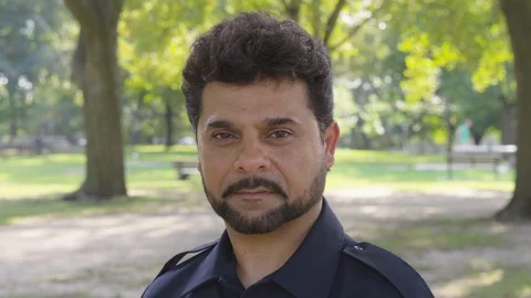 Static shot of a man in a park and staring into the camera - shot on RED Stock Footage 124719755