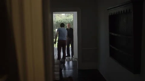 Static shot of man talking to a priest at his front door Stock Footage 202908737